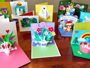 Colorful pop-up cards with intricate 3D designs on table.